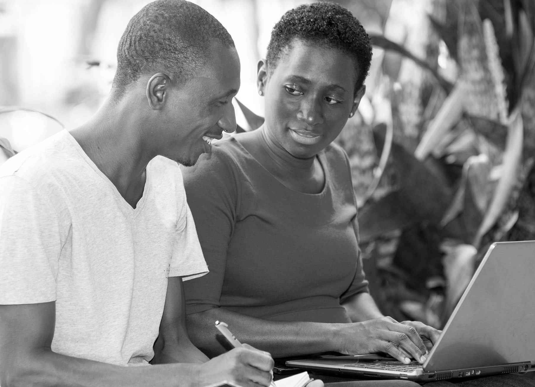 young students sitting in park with laptop doing research while smiling.; Shutterstock ID 1123613330; PO/JOB: -; CLIENTE: -; CNPJ: -; VENCIMENTO: -