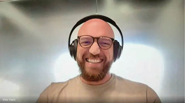 A man wearing headphones and glasses is smiling. Description generated by AI