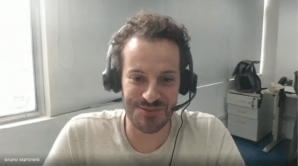 A man wearing headphones and a white shirt. Description generated by AI
